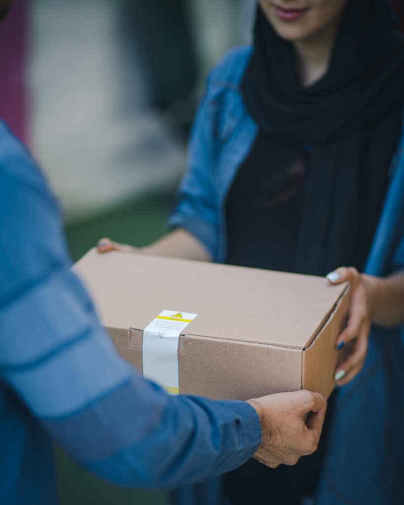 Individual delivering a box to a neighborhood resident.